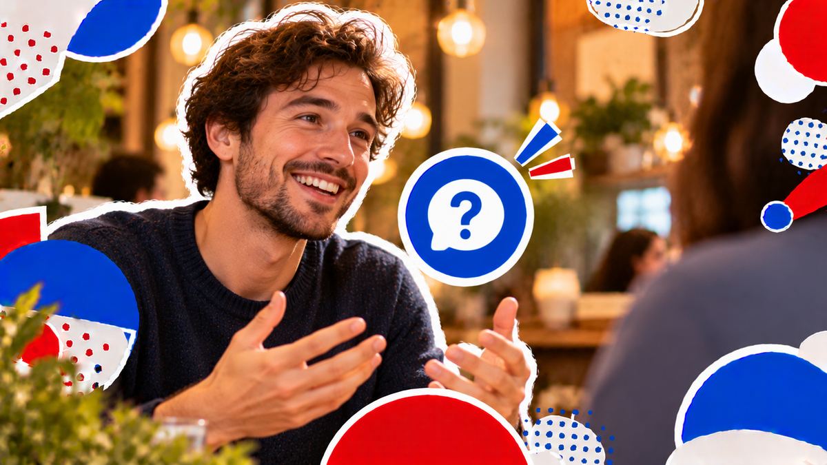 A man smiling as he answers a question, seen up close in the warm light of a café
